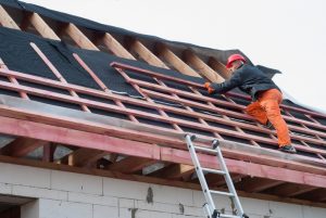 Worker installs bearing laths on the truss system